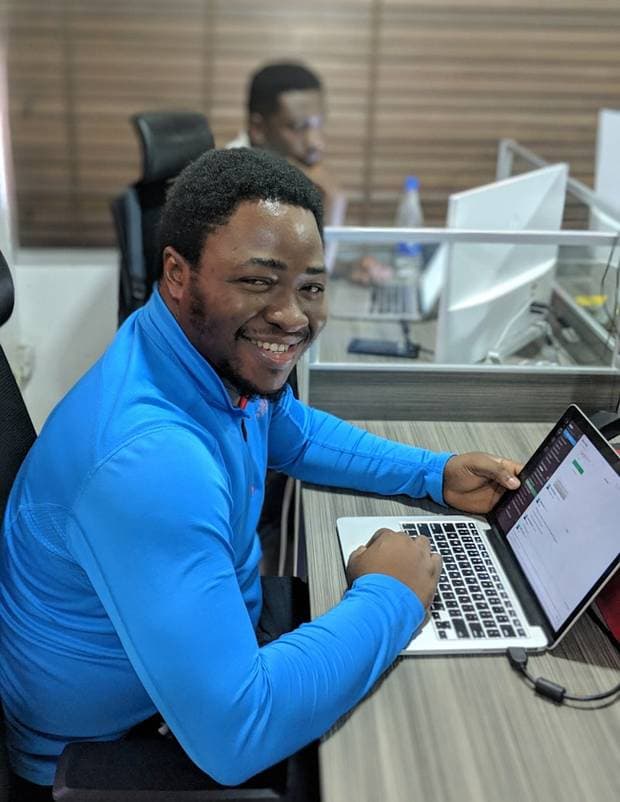 A Nyansa AI customer at their desk, smiling after getting a cited answer
